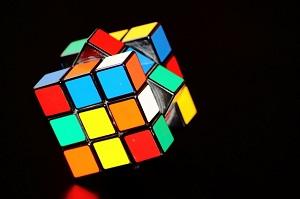 Unsolved Rubiks cube against a black background